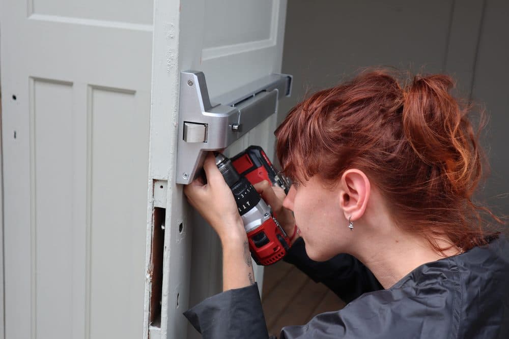 Técnica instalando una cerradura nueva en una puerta